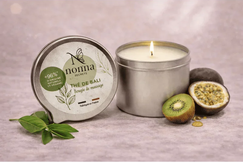 Bougie de massage naturelle dans une boîte en métal avec kiwi, fruits exotiques et feuilles vertes